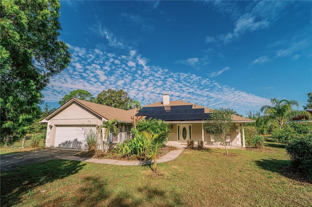 ranch-style house featuring a garage, a front lawn, and solar panels