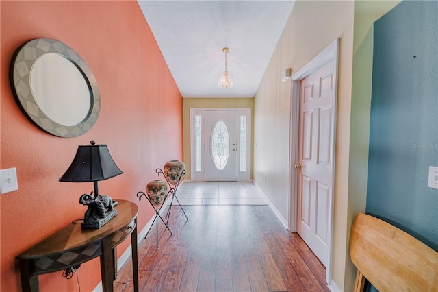 entryway featuring hardwood / wood-style floors and a chandelier