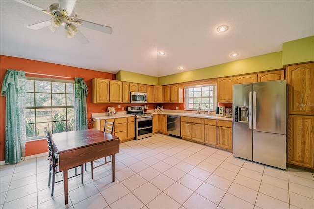 kitchen featuring ceiling fan, stainless steel appliances, and light tile patterned floors