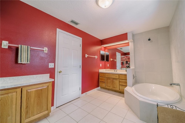 bathroom featuring tile patterned floors, a bathtub, vanity, and a textured ceiling