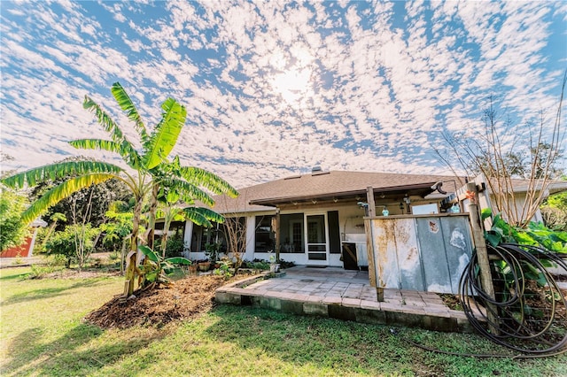 rear view of house featuring a patio area and a lawn