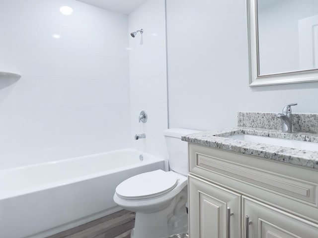 full bathroom with hardwood / wood-style flooring, tiled shower / bath, vanity, and toilet