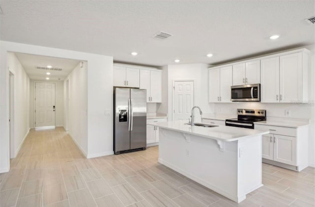 kitchen with white cabinetry, an island with sink, appliances with stainless steel finishes, and sink