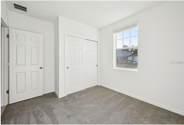 unfurnished bedroom featuring carpet flooring and a closet