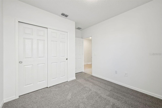 unfurnished bedroom with carpet flooring and a closet