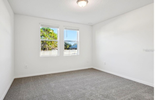 carpeted spare room featuring a textured ceiling