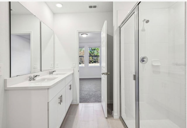 bathroom with vanity and a shower with door