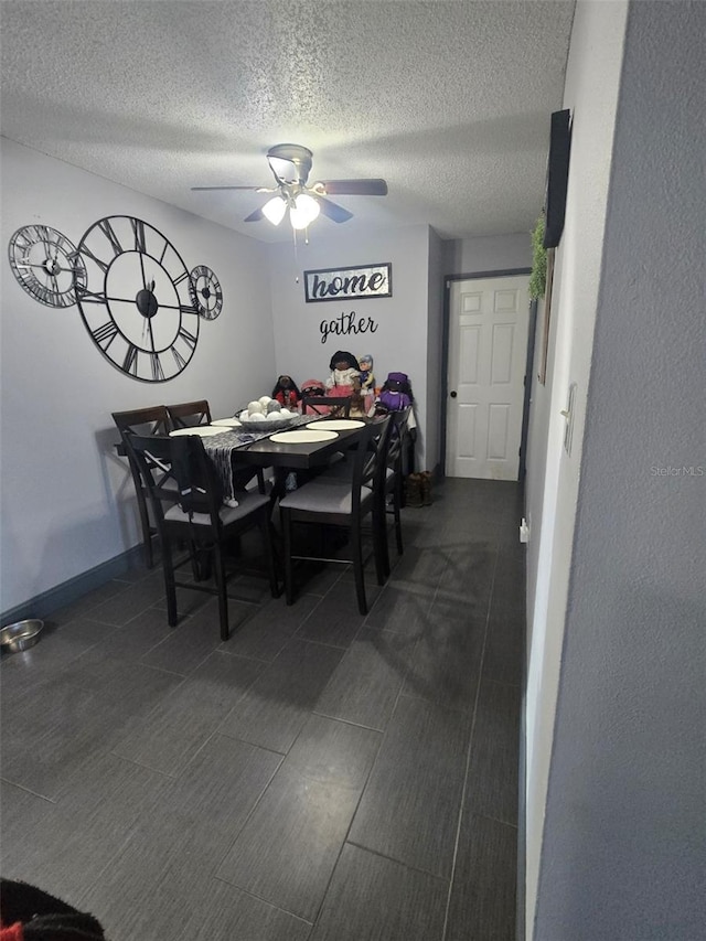 dining area featuring ceiling fan and a textured ceiling