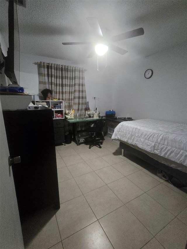 tiled bedroom featuring a textured ceiling and ceiling fan