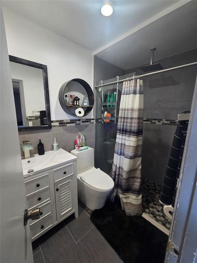 bathroom with vanity, toilet, a shower with shower curtain, and tile walls