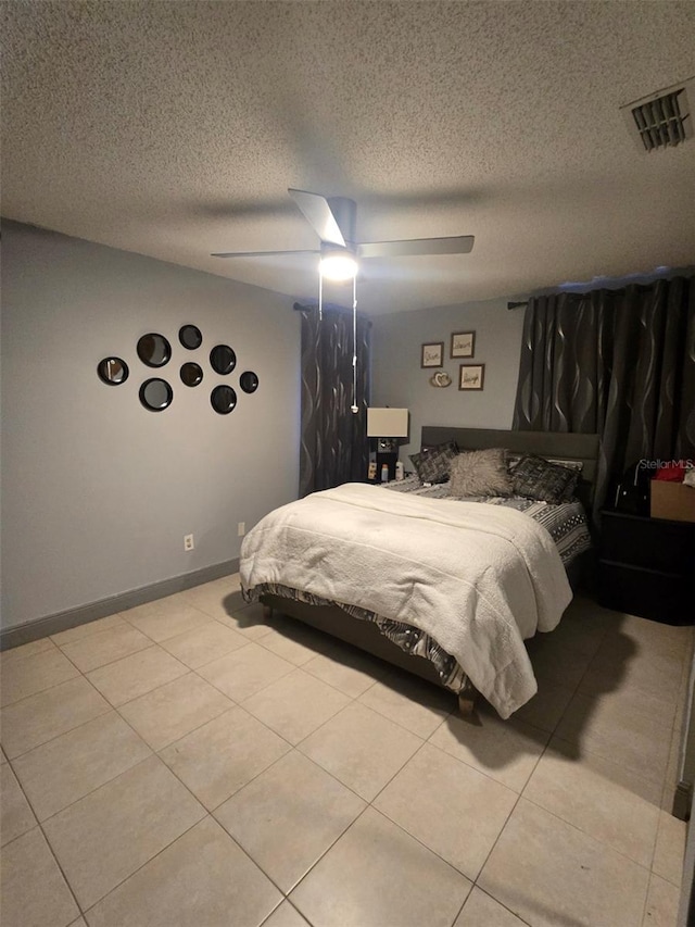 bedroom featuring light tile patterned floors, a textured ceiling, and ceiling fan