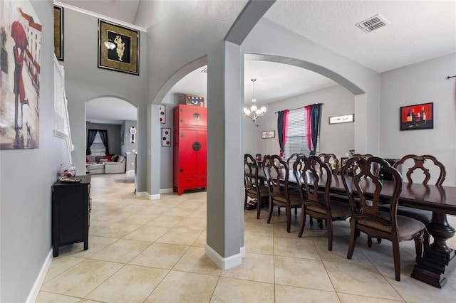 dining room with a chandelier, a textured ceiling, and light tile patterned floors