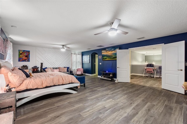 bedroom featuring hardwood / wood-style floors, a textured ceiling, and ceiling fan