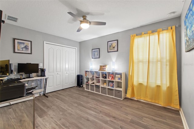 office with ceiling fan, hardwood / wood-style floors, and a textured ceiling