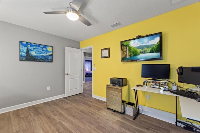 office featuring wood-type flooring, a textured ceiling, and ceiling fan