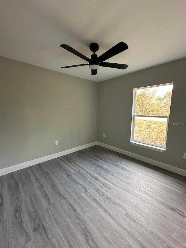 spare room with ceiling fan and light wood-type flooring