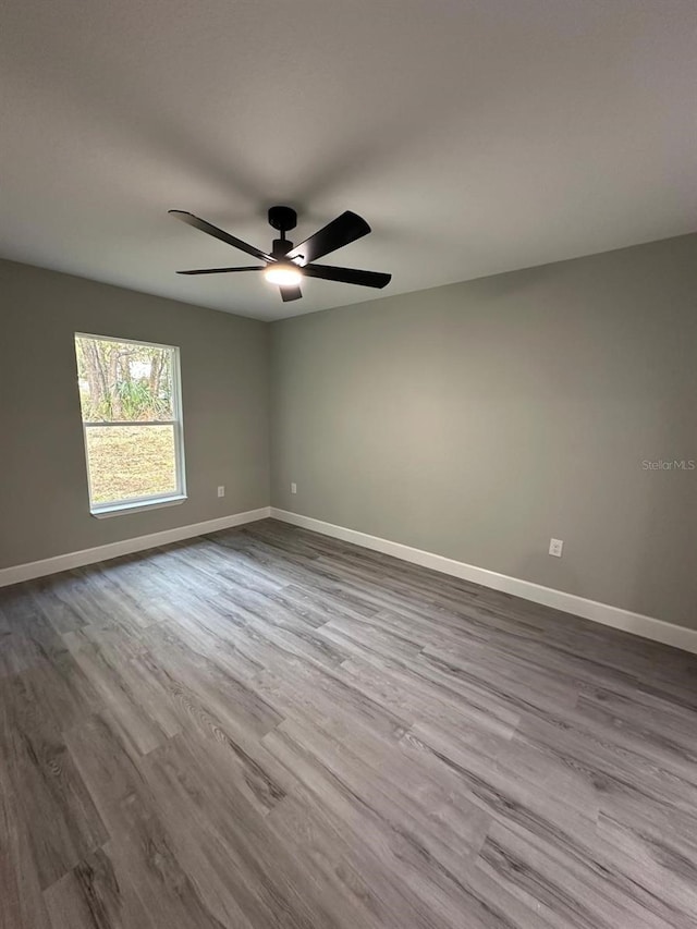 spare room with ceiling fan and light wood-type flooring