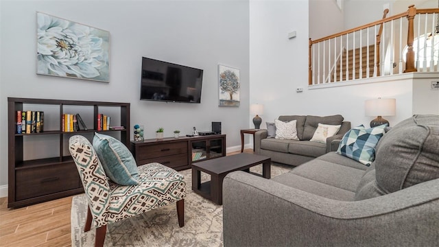 living room featuring light hardwood / wood-style floors and a high ceiling