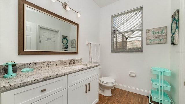 bathroom with vanity, hardwood / wood-style flooring, and toilet