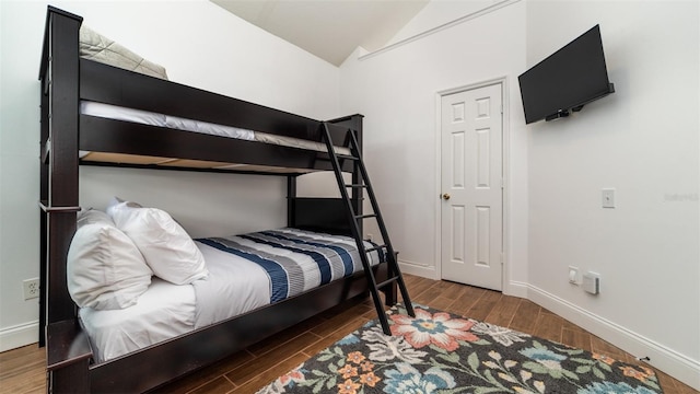 bedroom with vaulted ceiling and dark hardwood / wood-style floors