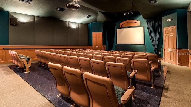 carpeted home theater room featuring lofted ceiling and a textured ceiling