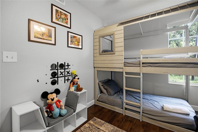 bedroom featuring multiple windows, dark hardwood / wood-style flooring, and a textured ceiling