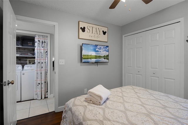 bedroom with dark hardwood / wood-style floors, washing machine and clothes dryer, ceiling fan, a textured ceiling, and a closet