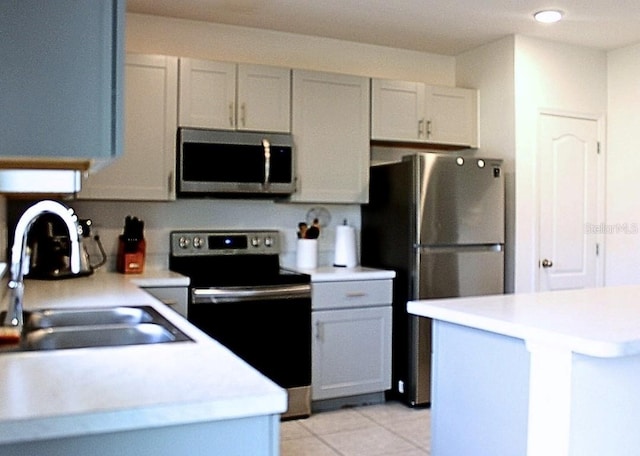 kitchen featuring stainless steel appliances, sink, and light tile patterned floors