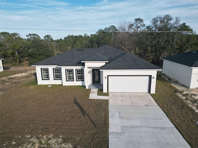 view of front of house featuring a garage and a front lawn