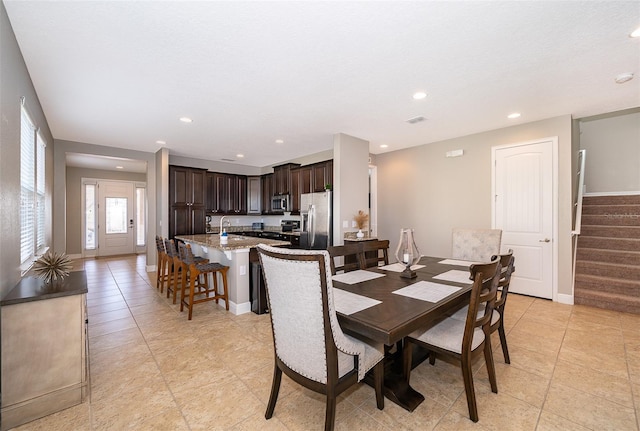 dining room featuring sink and light tile patterned floors