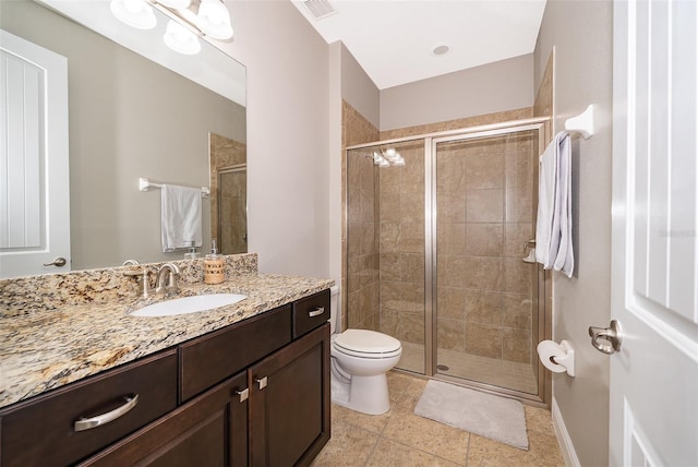 bathroom with tile patterned floors, vanity, toilet, and a shower with shower door