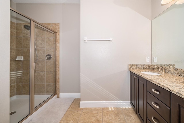 bathroom with tile patterned flooring, vanity, and walk in shower