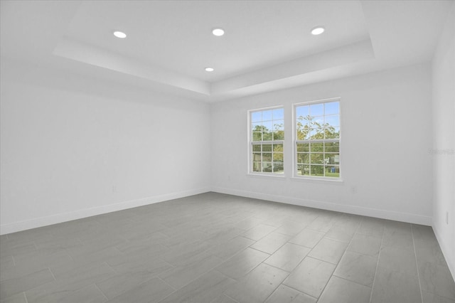 empty room featuring a raised ceiling