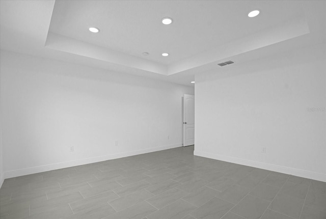 unfurnished room with a tray ceiling