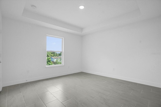 unfurnished room with a tray ceiling