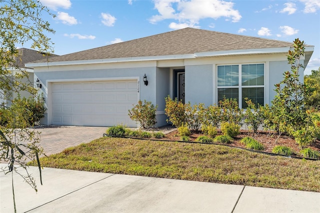 ranch-style home featuring a garage and a front lawn