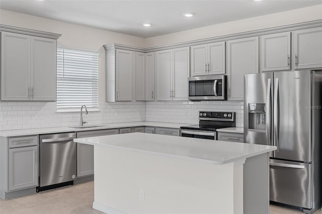 kitchen with decorative backsplash, stainless steel appliances, sink, and a kitchen island