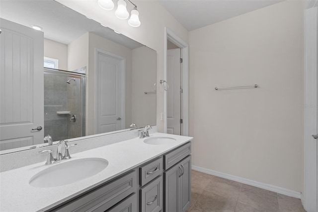 bathroom with a shower with door, vanity, and tile patterned floors