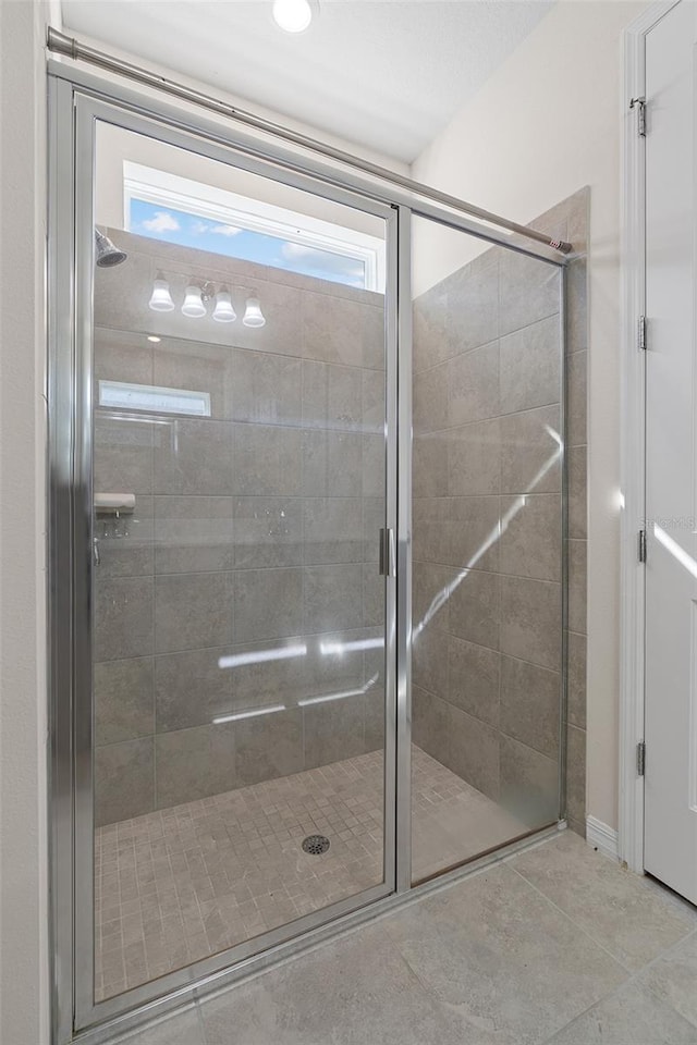 bathroom with a healthy amount of sunlight, an enclosed shower, and tile patterned floors