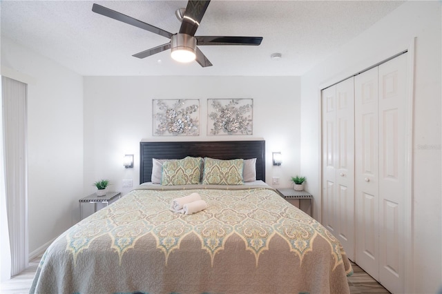 bedroom featuring a textured ceiling, a closet, ceiling fan, and light wood-type flooring