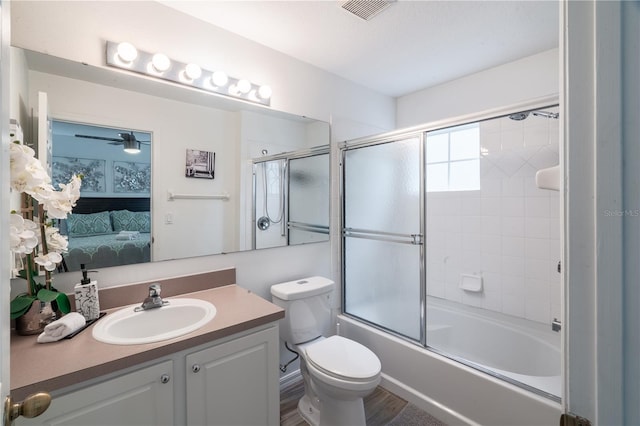 full bathroom featuring vanity, ceiling fan, shower / bath combination with glass door, and toilet