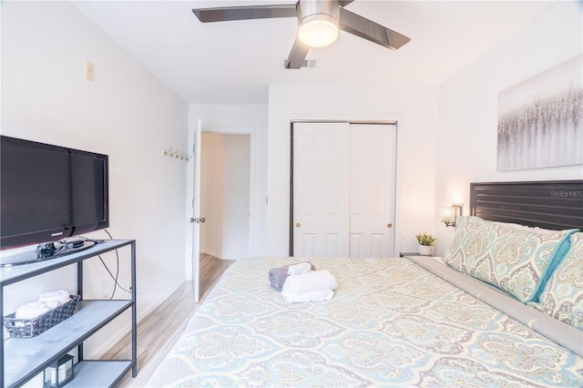 bedroom featuring light hardwood / wood-style floors, a closet, and ceiling fan