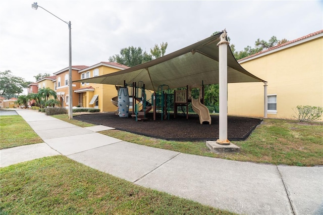 exterior space with a playground and a lawn