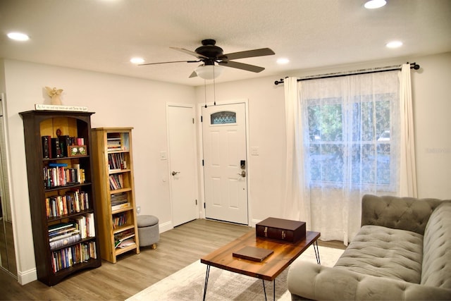 living room with light hardwood / wood-style flooring and ceiling fan