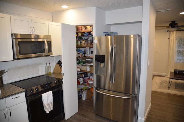 kitchen featuring white cabinetry, dark stone countertops, dark hardwood / wood-style floors, ceiling fan, and stainless steel appliances