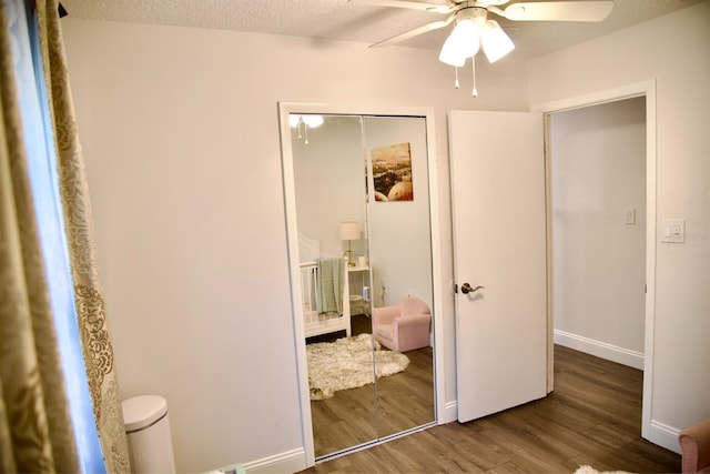 unfurnished bedroom with dark hardwood / wood-style flooring, a textured ceiling, ceiling fan, and a closet