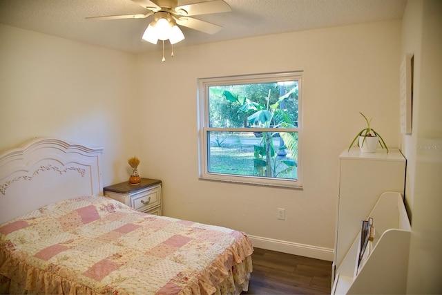 bedroom featuring dark wood-type flooring, a textured ceiling, and ceiling fan