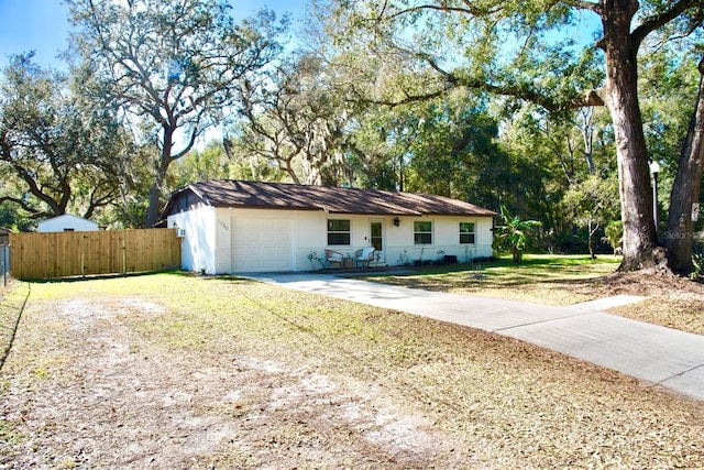 single story home with a front yard, fence, concrete driveway, a garage, and brick siding