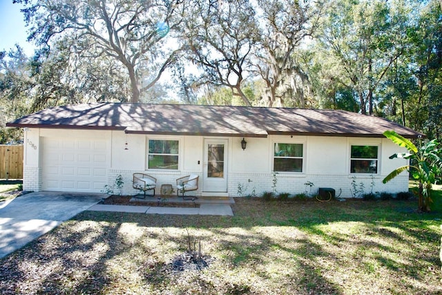 single story home featuring a front yard, fence, concrete driveway, a garage, and brick siding