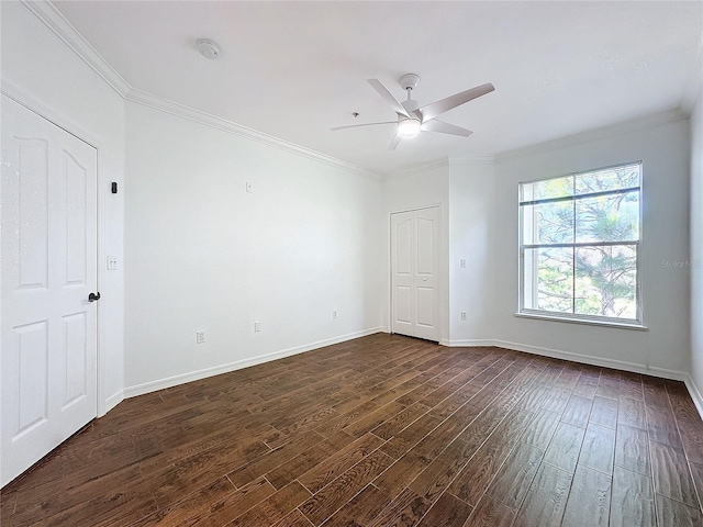 empty room with ornamental molding, dark hardwood / wood-style floors, and ceiling fan